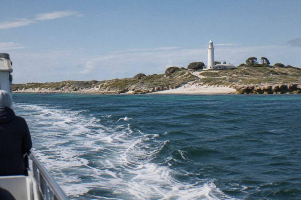 A passenger ferry crossing open water toward an island coastline