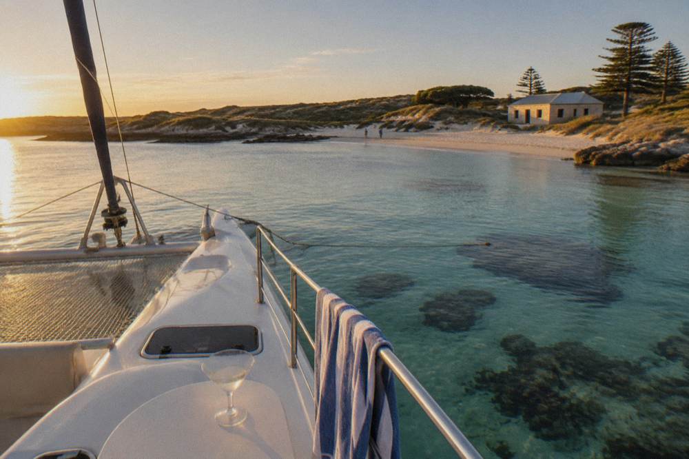 A catamaran moored in clear shallow water above a coral reef