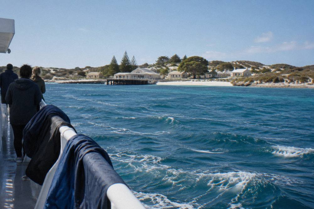 A passenger ferry crossing open water between the mainland coast and Rottnest Island