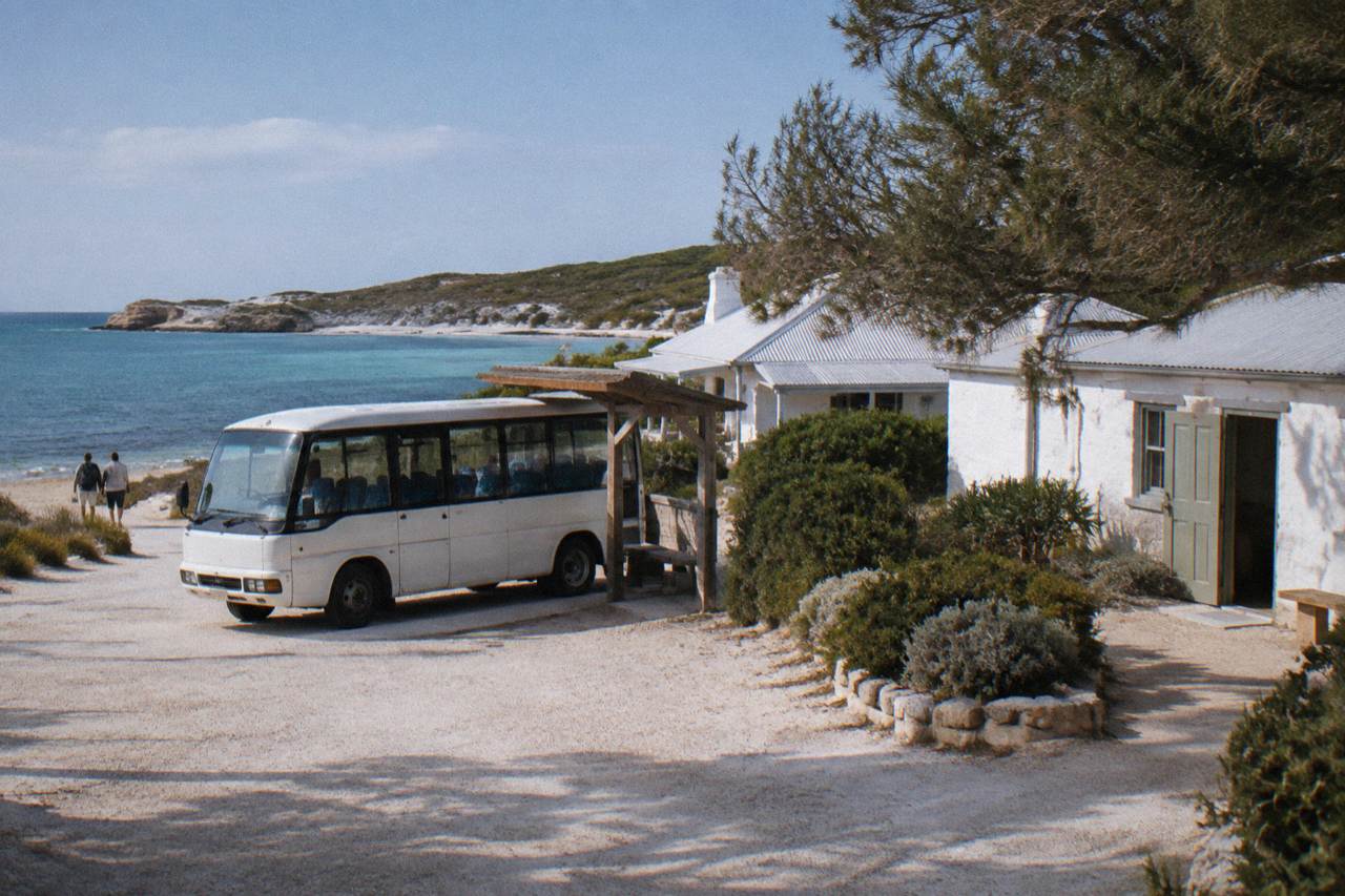 A small passenger bus parked beside the shore at Thomson Bay settlement on Rottnest Island