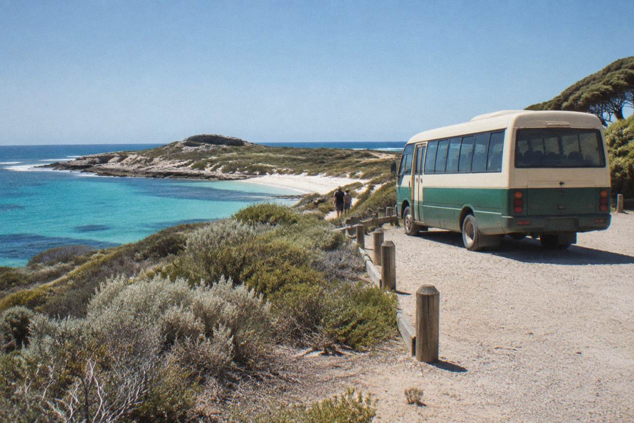 A shuttle bus parked beside a calm turquoise bay on a small island