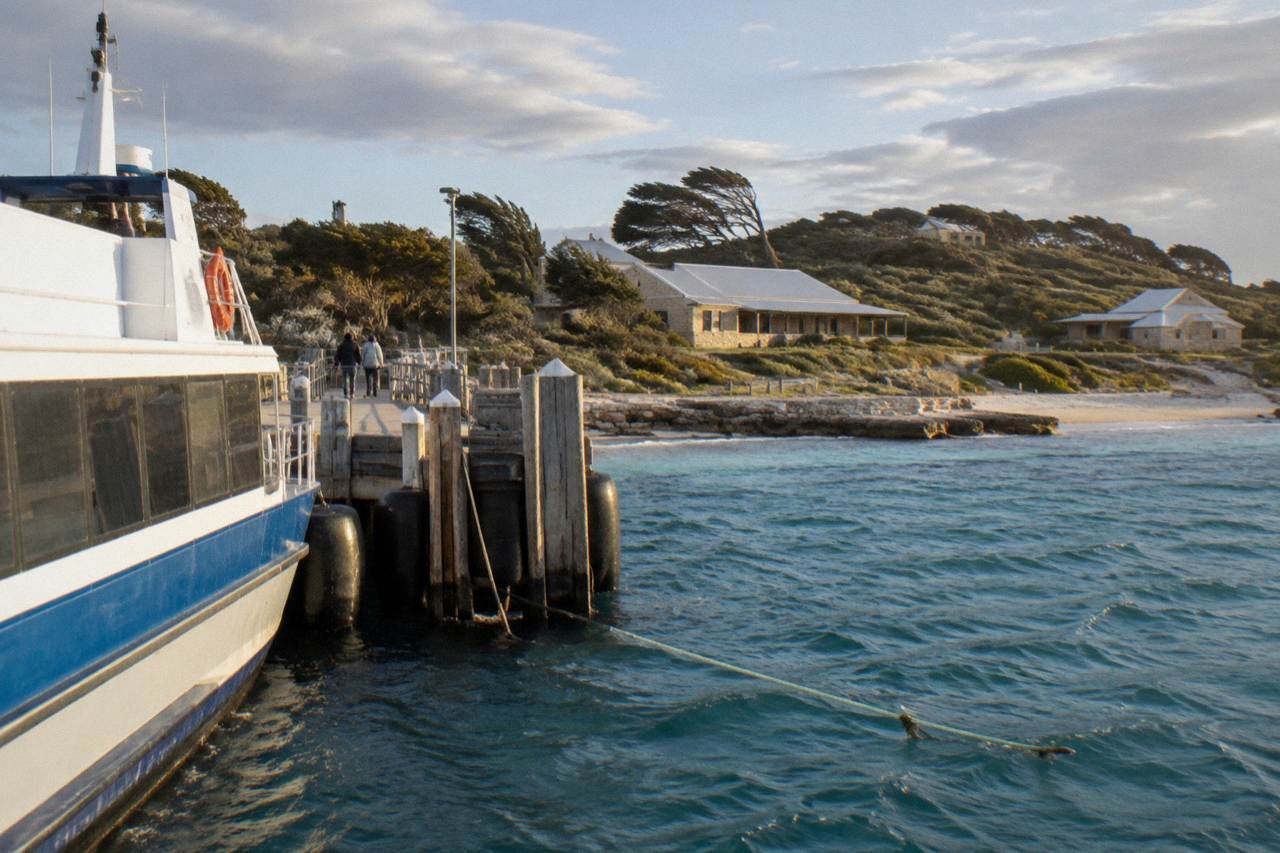 A ferry at the jetty on Rottnest Island with bicycles lined up on the shore