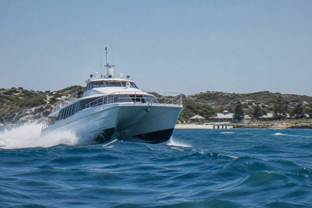 A fast ferry cutting across open water toward Rottnest Island