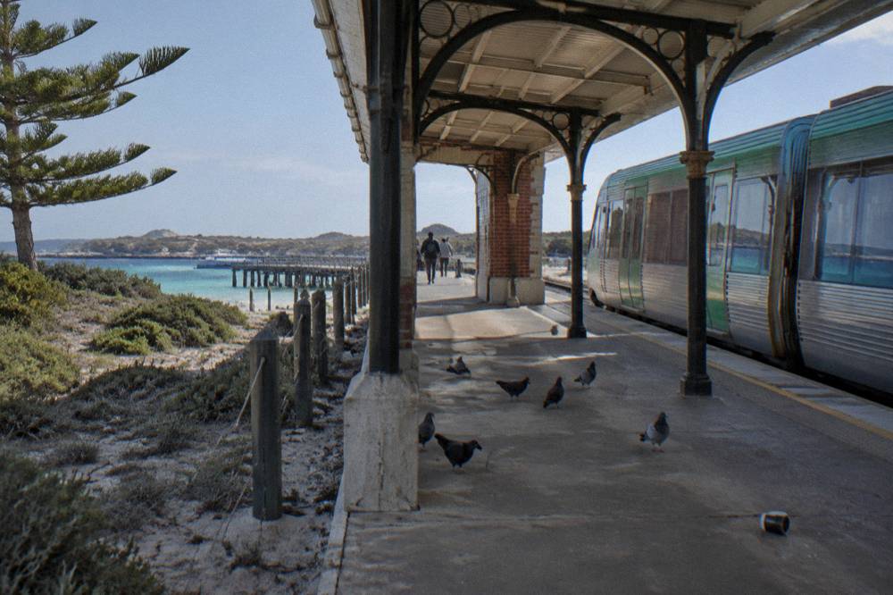 A train platform and heritage buildings near Fremantle station on a clear morning