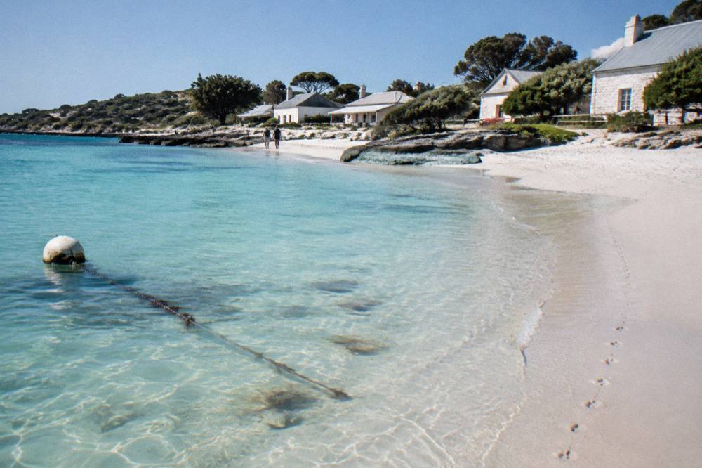 Turquoise water and white sand at Thomson Bay with the settlement behind