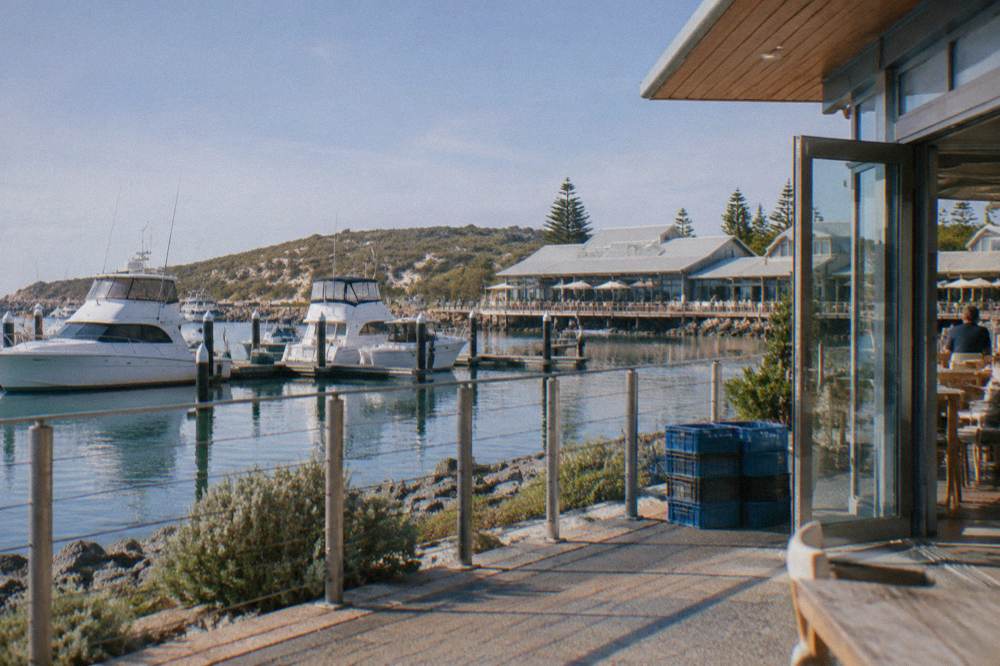 Boats moored in Hillarys Boat Harbour with restaurants along the waterfront