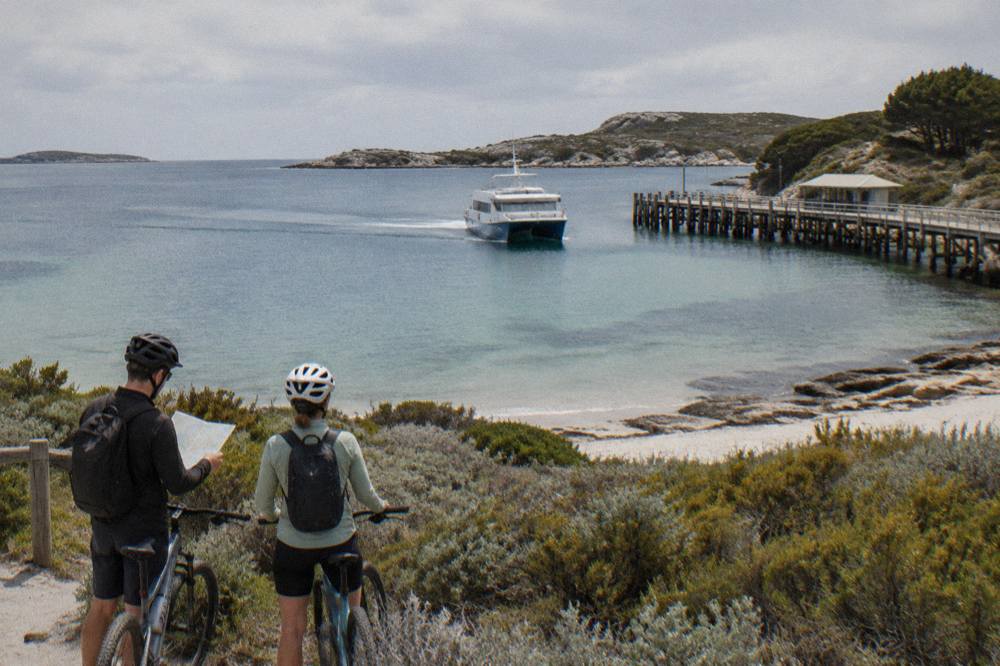 A ferry approaching the jetty at Thomson Bay with cyclists waiting on the shore