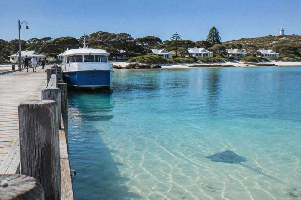 A ferry at a jetty above clear shallow water at Rottnest Island