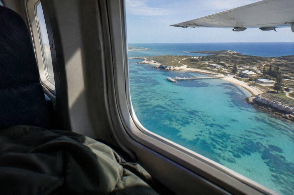 A light aircraft cabin interior showing a window seat over a wing.