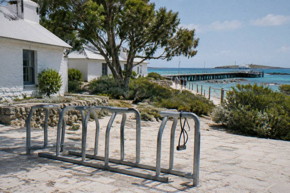 Bicycles leaning on a rack near the Thomson Bay settlement with ferry jetty in the distance