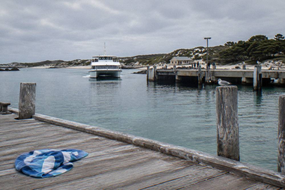 A ferry approaching a jetty across calm blue water