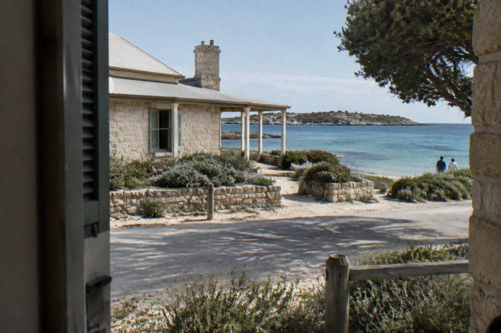 Heritage stone buildings of the Thomson Bay settlement beside a calm bay