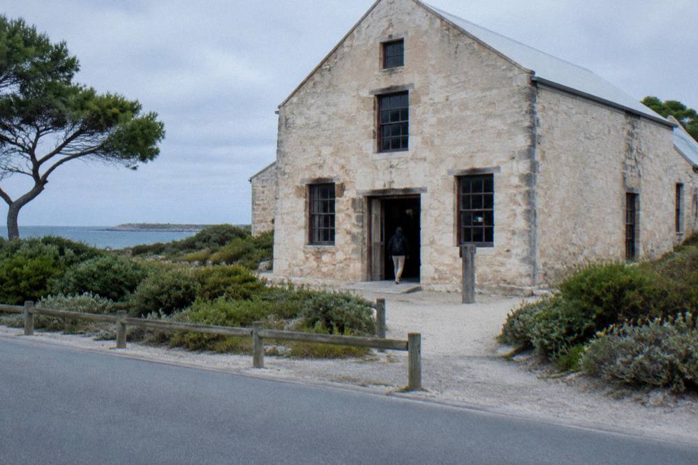 Bicycles parked beside a heritage stone building near the Thomson Bay settlement